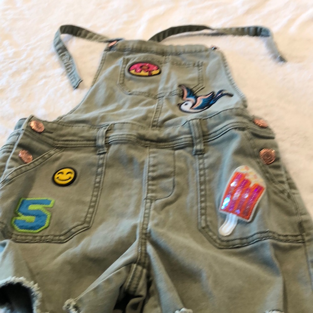 Navy green overalls with patches.